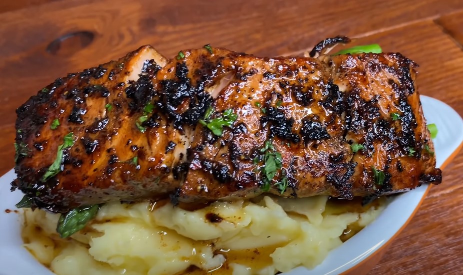 Seared salmon, perfectly seasoned, rests atop creamy mashed potatoes