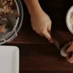 Hands deveining shrimp with a knife, showing how to devein shrimp